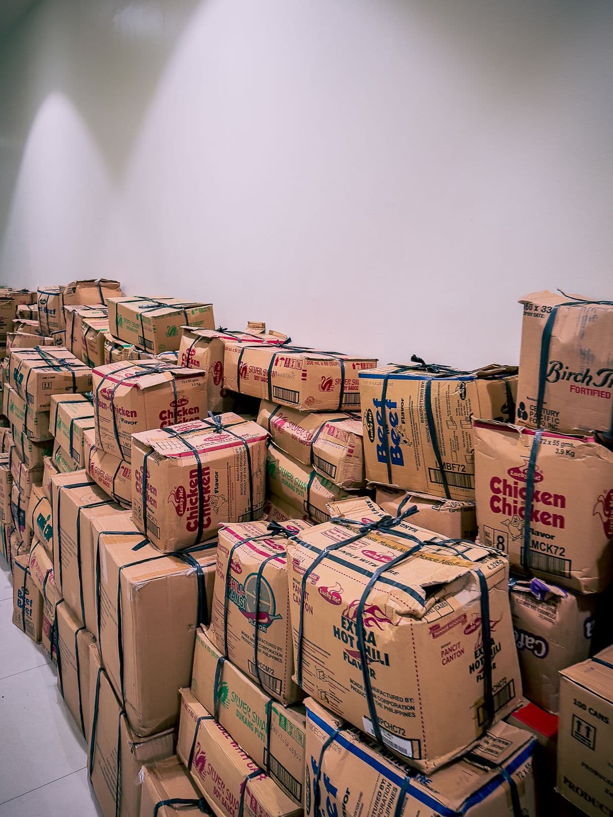 Balikbayan boxes tied with twine, stacked and ready for the next pickup run